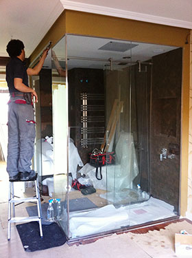 Ejemplo baño con ducha de acero y paredes de cristal