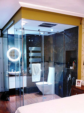 Ejemplo baño con ducha de acero y paredes de cristal